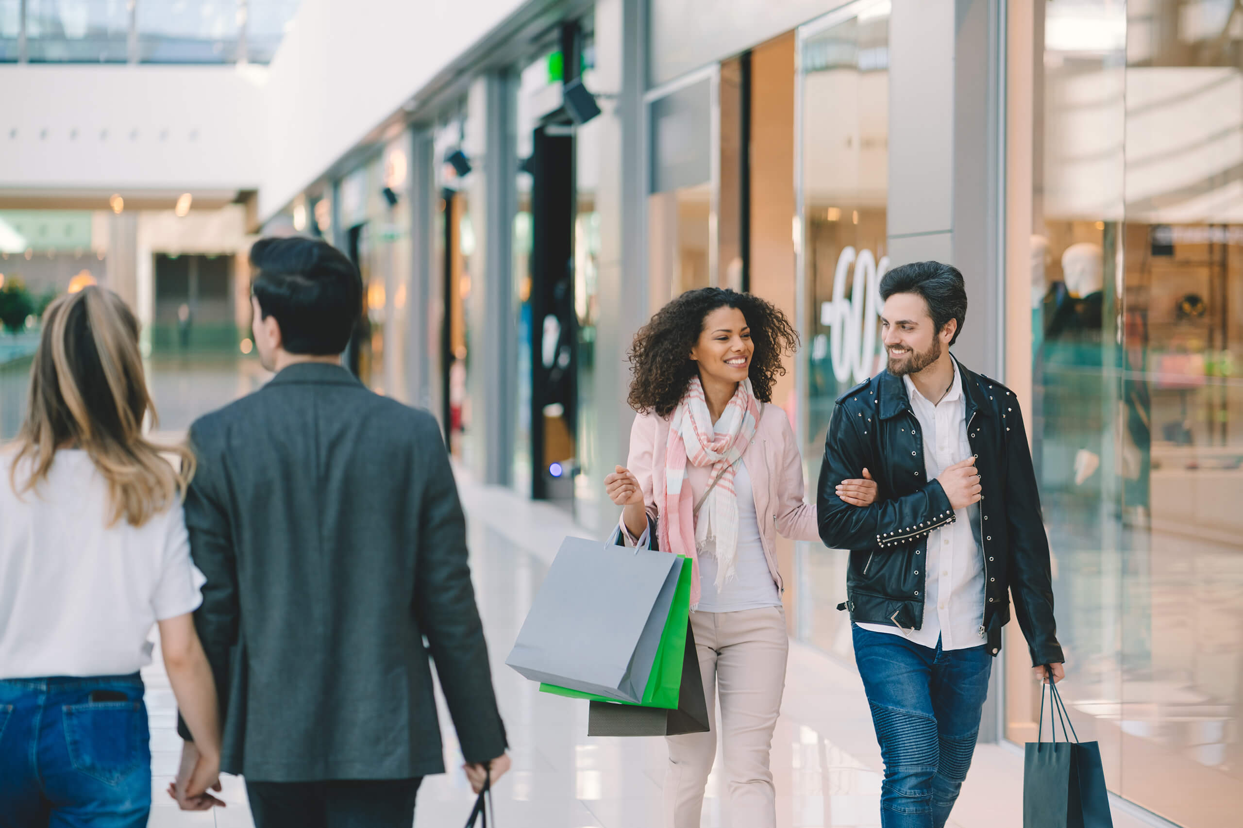 Shoppers carrying bags through a shopping center