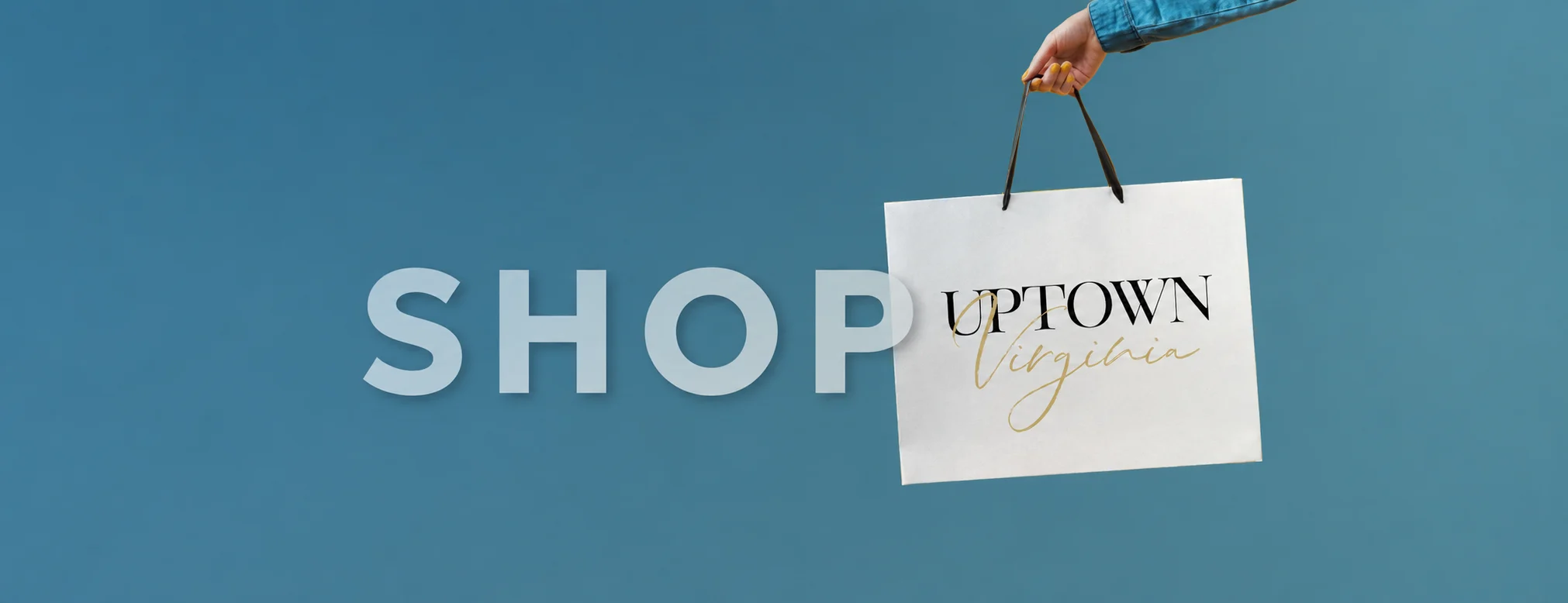 Shop Uptown Virginia: a hand holding an Uptown Virginia shopping bag